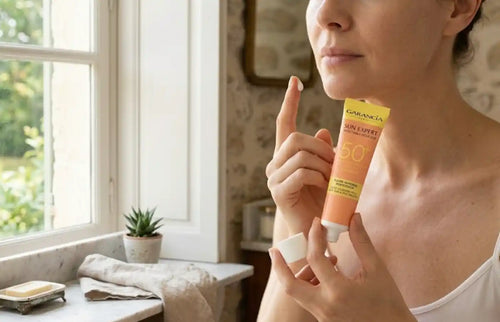 Femme appliquant de la crème solaire Garancia Sun Expert SPF 50+.