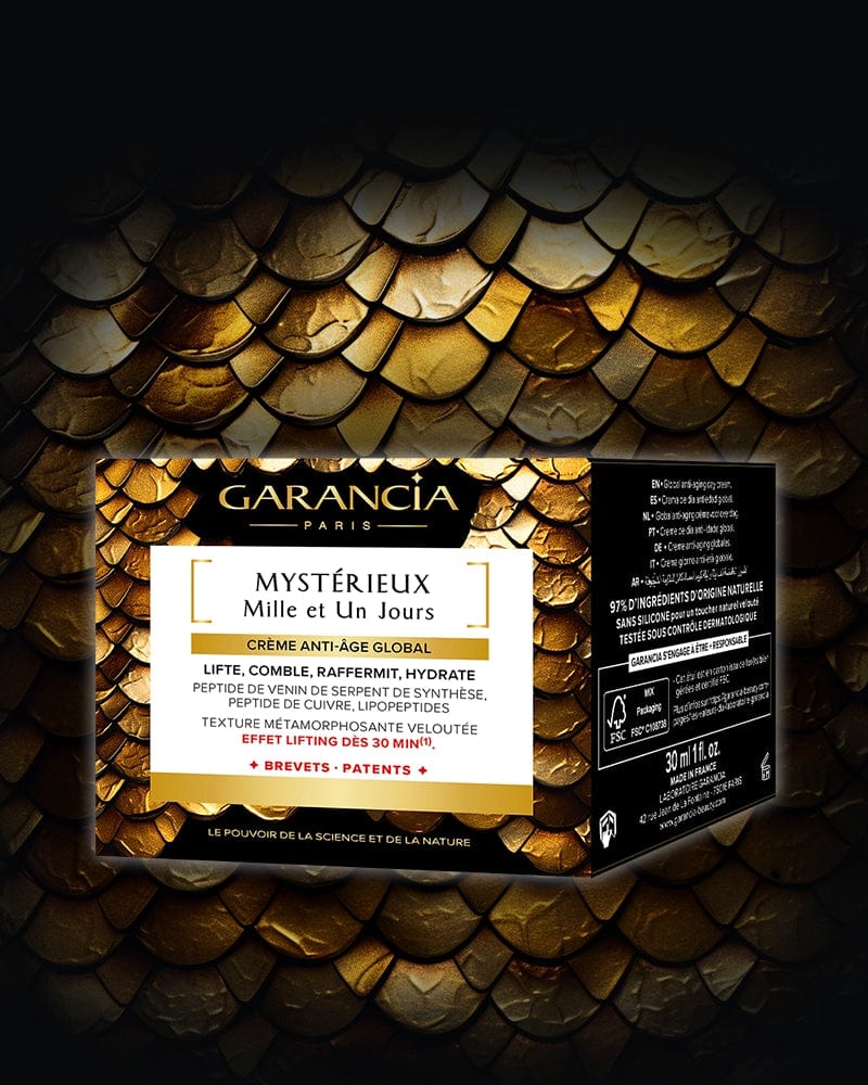 Laboratoire Garancia Anti-Âge & Anti-Rides [ MYSTÉRIEUX Mille et Un Jours ] : posée sur un fond d'écailles de serpent dorées et noires. L'étiquette principale mentionne les actions : lifte, comble, raffermit, hydrate. Le côté droit du packaging détaille le volume (30ml) et la mention 97% d'ingrédients d'origine naturelle.