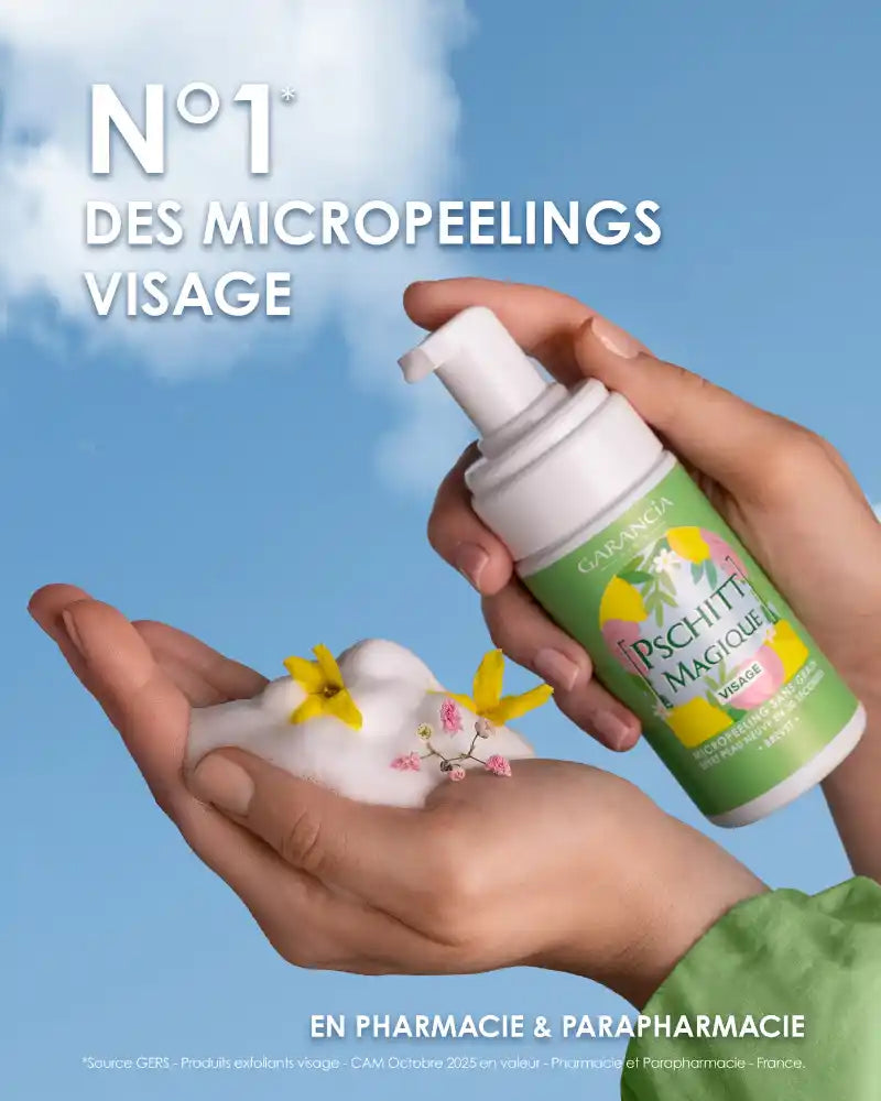 Utilisation du Pschitt Magique Garancia : une main recueille la mousse onctueuse décorée de petites fleurs jaunes, avec le flacon édition limitée sur un fond de ciel bleu printanier.