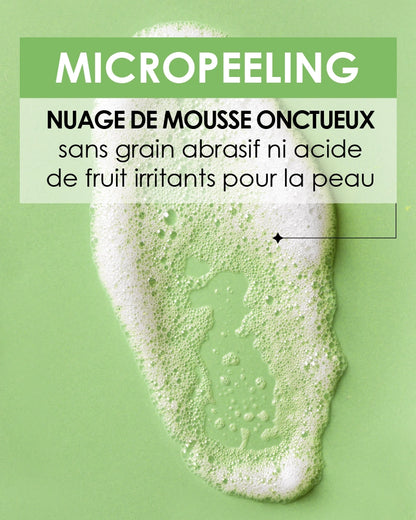 Gros plan sur la texture du Pschitt Magique Garancia : un nuage de mousse onctueux blanc sur fond vert, avec un texte précisant une formule sans grain abrasif ni acide de fruit irritant.